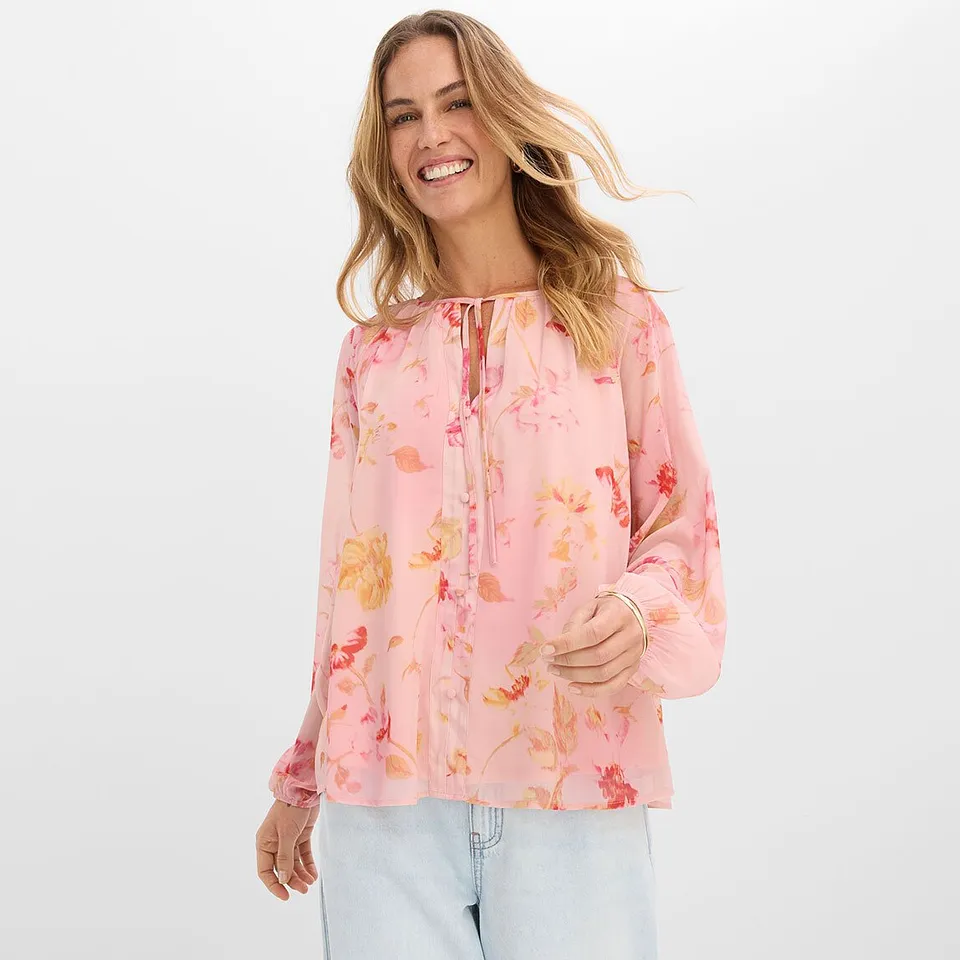 Rosa bluse med blomsterm&oslash;nster og lyse jeans.