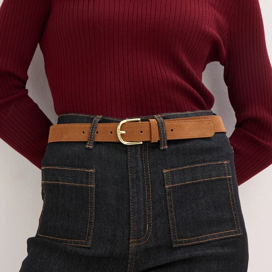 Strikket genser kombinert med jeans og brunt skinnbelte.