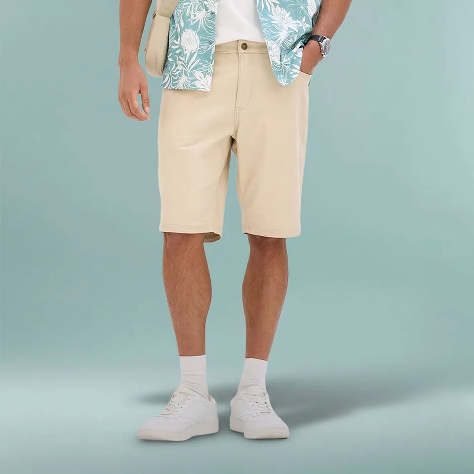 Coolt sommerantrekk med beige bermudashorts, m&oslash;nstret skjorte og hvite sneakers.