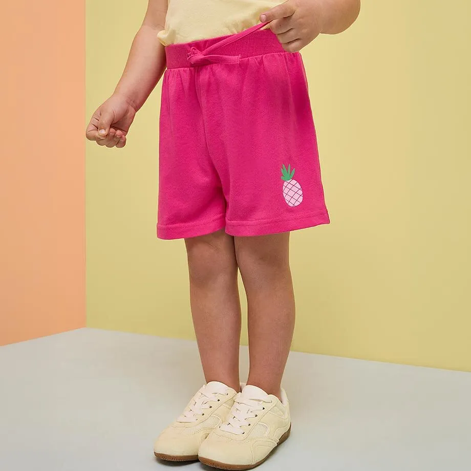 Rosa shorts med ananasmotiv og lys topp.