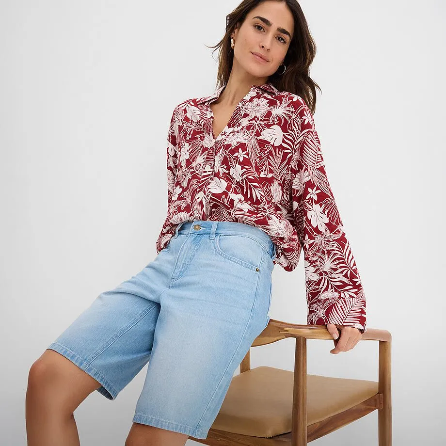 R&oslash;d og hvit m&oslash;nstret bluse med V-hals og lysebl&aring; denimshorts.