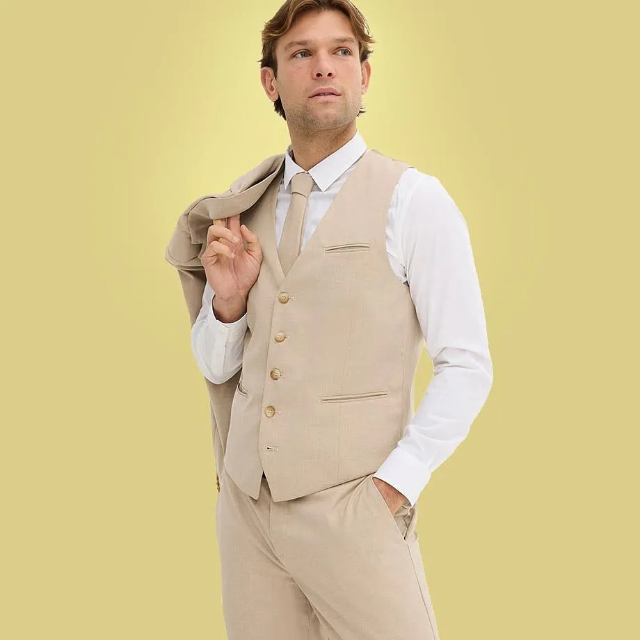 Person i beige dress med hvit skjorte og matchende vest.