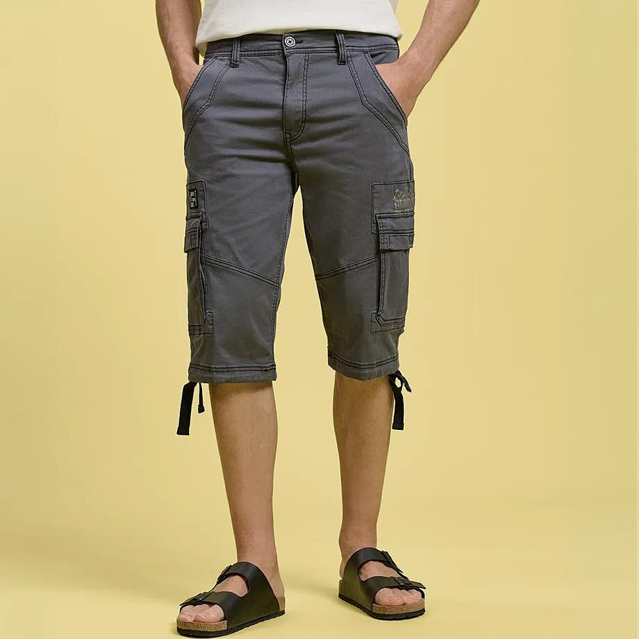 Gr&aring; cargoshorts med praktiske lommer, hvit T-skjorte og sorte sandaler.