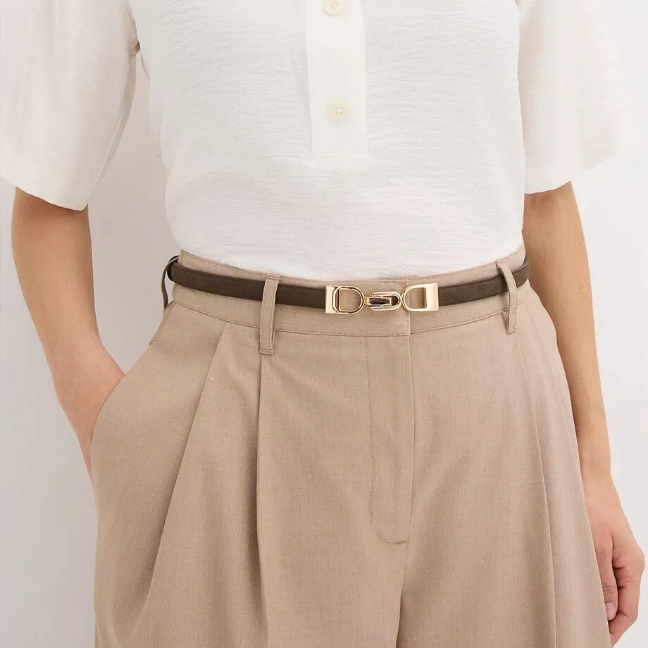 Hvit bluse, smalt belte med gullfarget spenne og beige bukse.