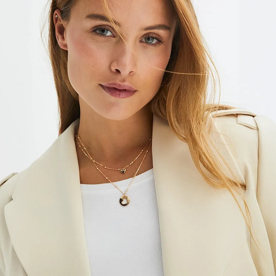 Person b&aelig;rer en lys beige blazer og et kjede.
