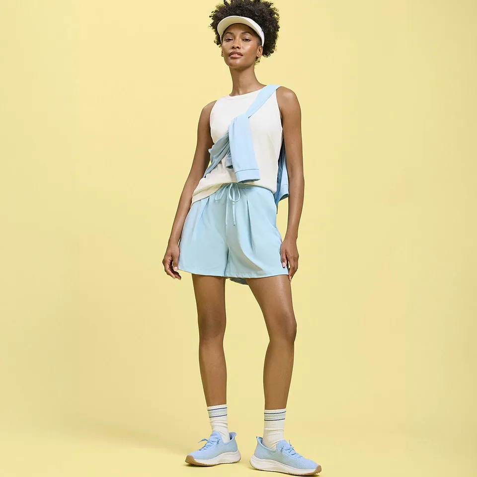 Hvit singlet, lysebl&aring; shorts og genser kombinert med joggesko og solskjerm.