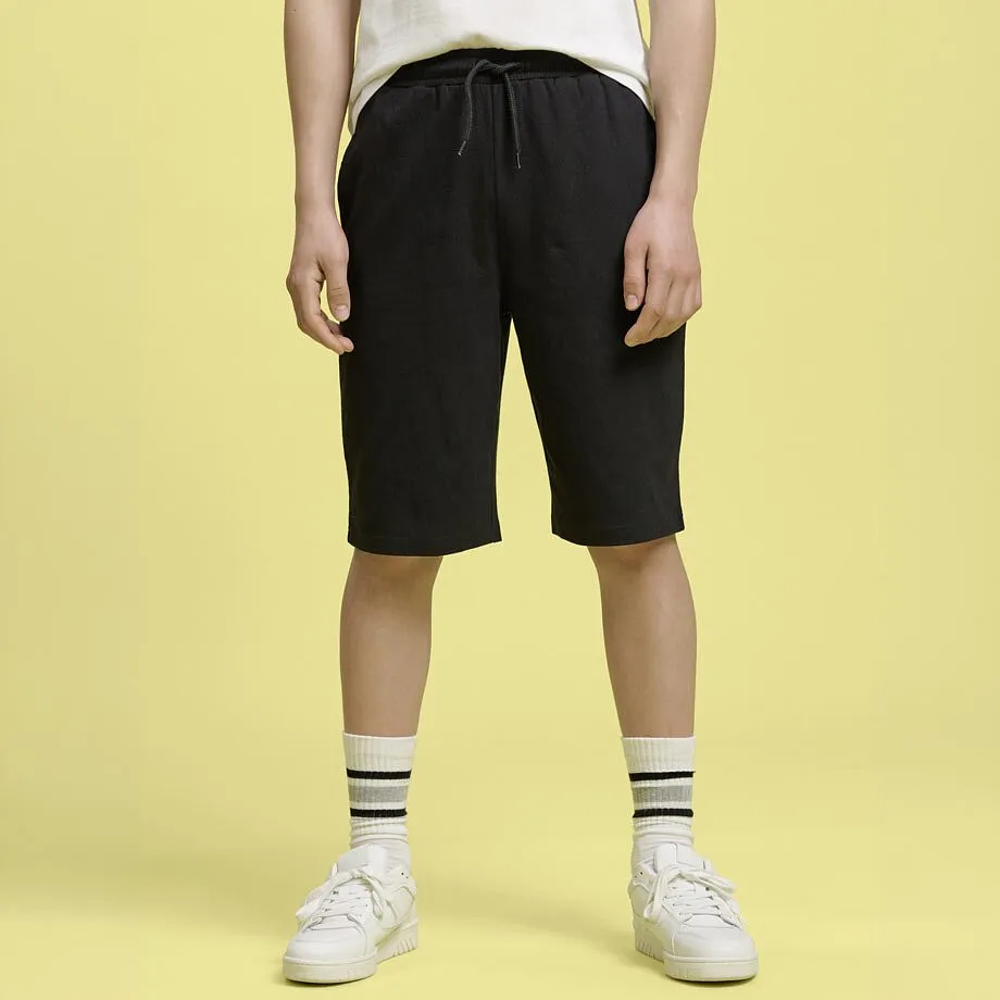 Outfit med hvit shirt og sort shorts.