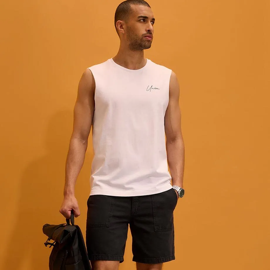 Hvit singlet, m&oslash;rk shorts og armb&aring;ndsur.