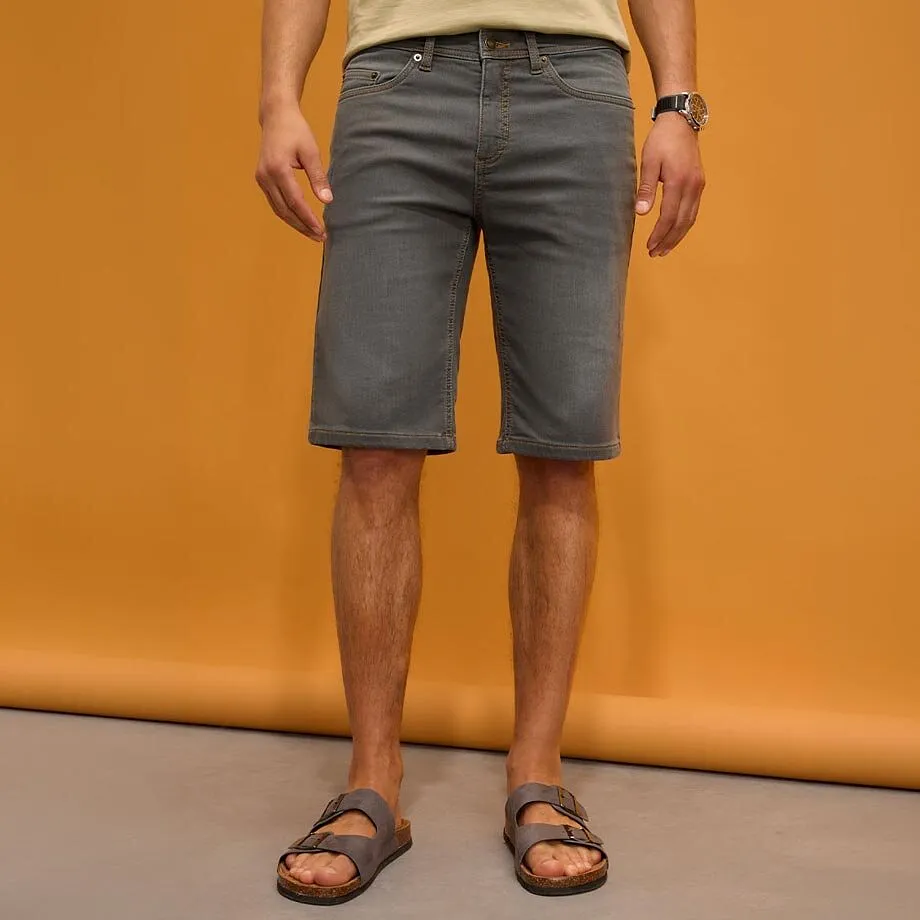 Gr&aring; shorts, lys T-skjorte og behagelige sandaler.