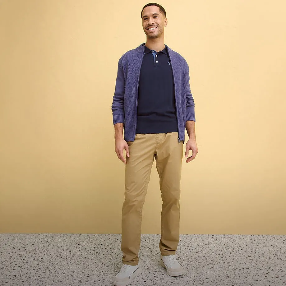 Lilla cardigan, m&oslash;rkebl&aring; poloskjorte, beige chinos, hvite sko.