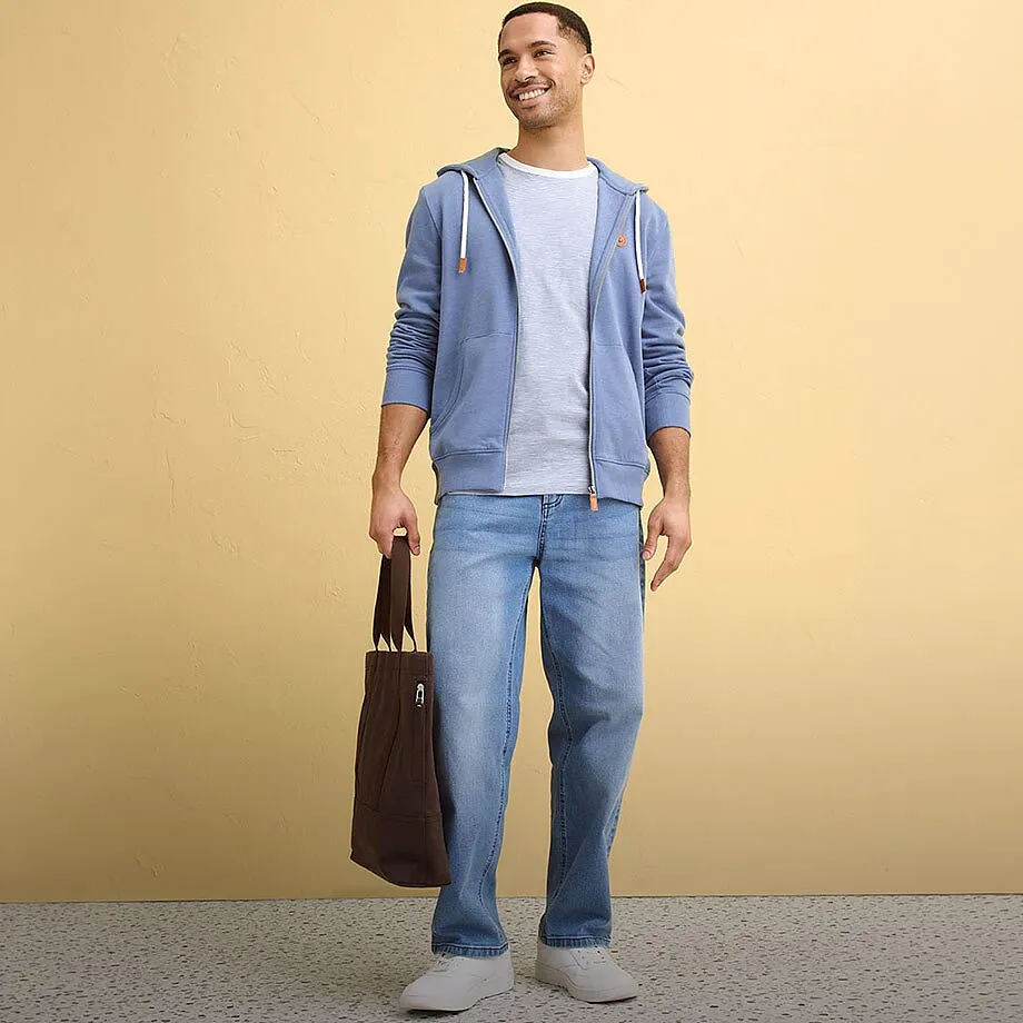 Bl&aring; hettegenser, lys T-skjorte, jeans og hvite sneakers s&oslash;rger for en avslappet stil.