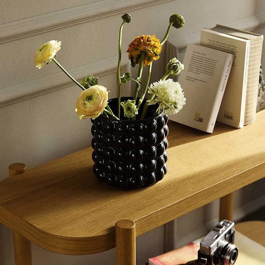 Blomster i vase p&aring; et trebord.