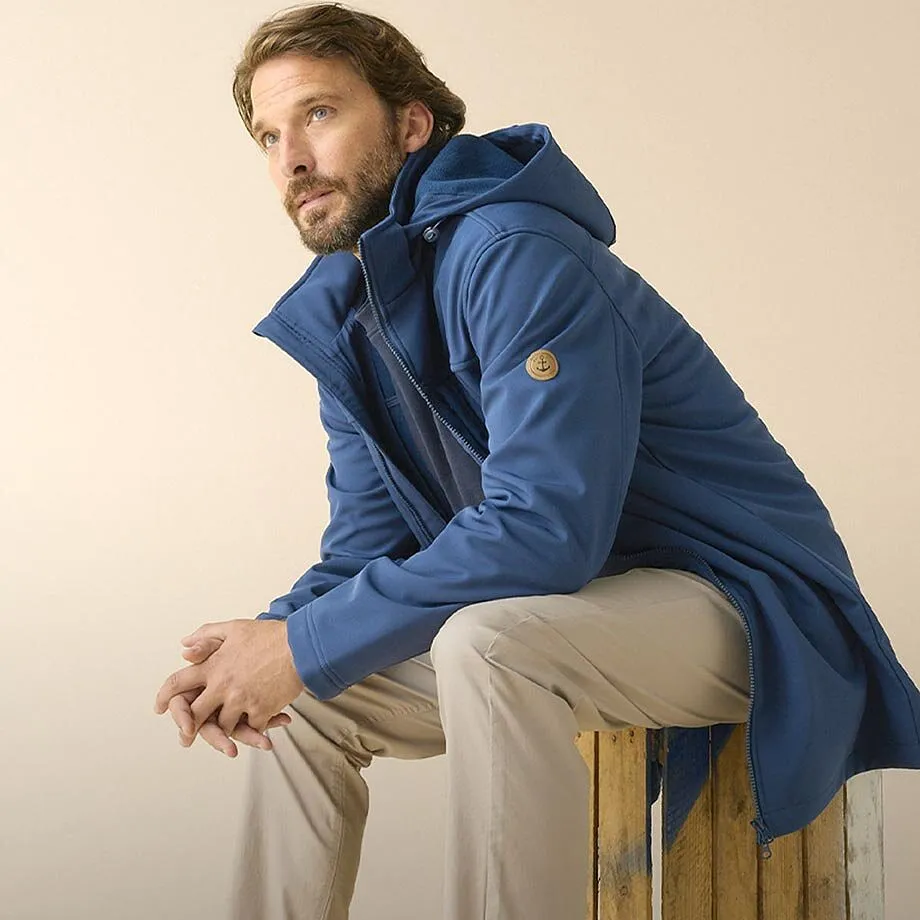 Bl&aring; parkas med hette, beige bukse og stilige sneakers.