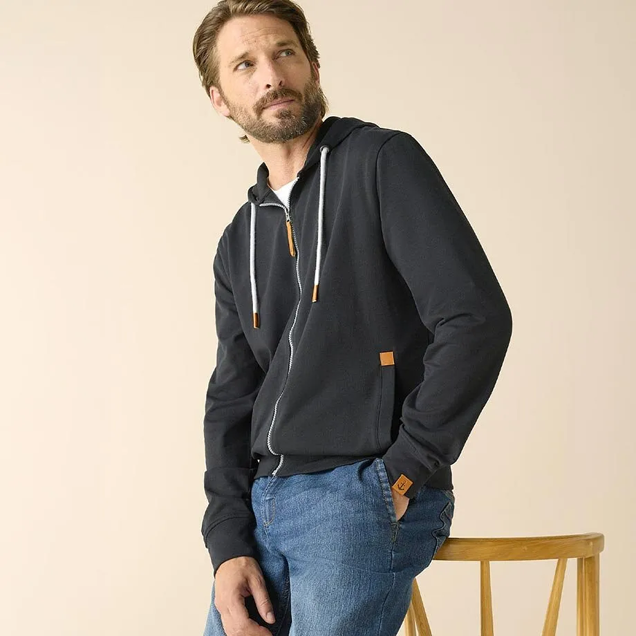 M&oslash;rk hettejakke, bl&aring; jeans, hvit T-skjorte.