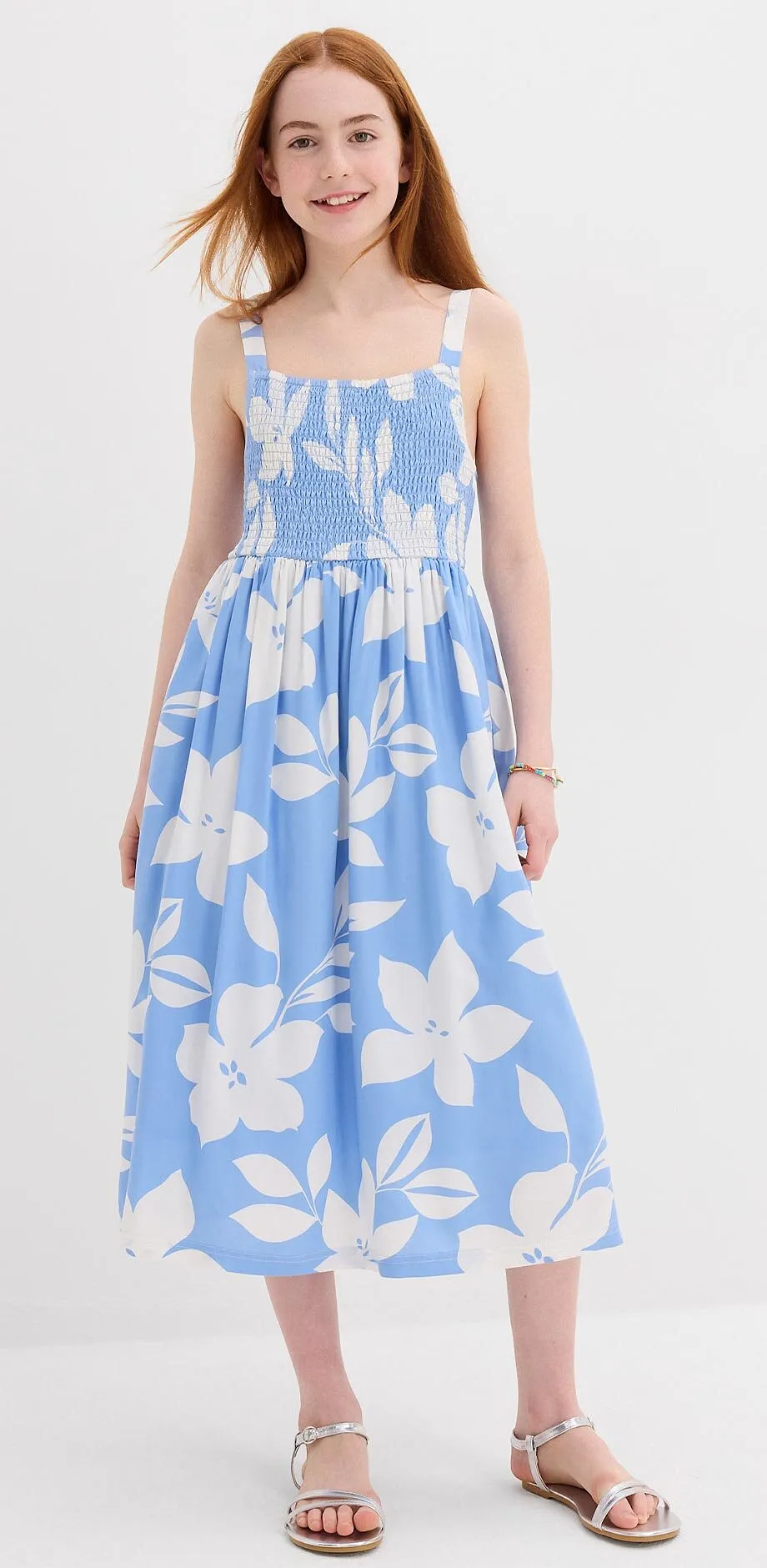Barn i lysebl&aring; sommerkjole med hvitt blomsterm&oslash;nster.