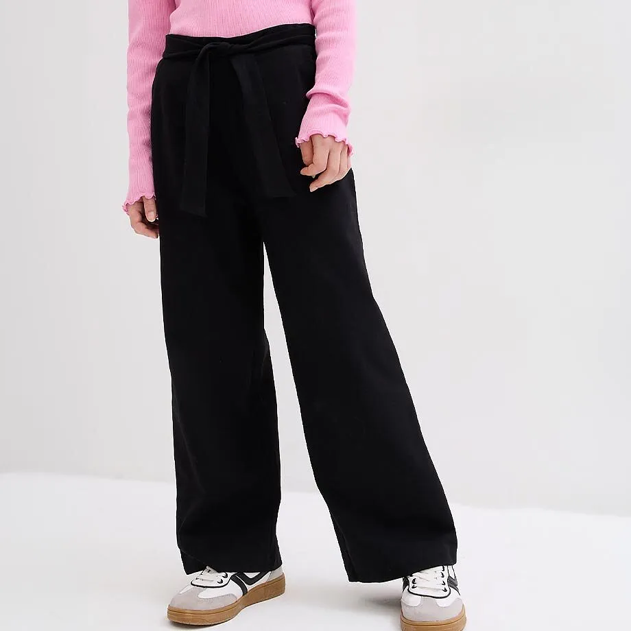 Rosa topp, sort, vid bukse med knyteb&aring;nd og sporty sneakers.