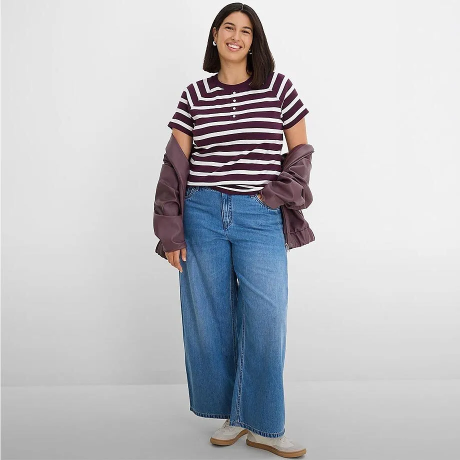 Moteriktig, stripete topp, vide jeans og avslappet jakke.
