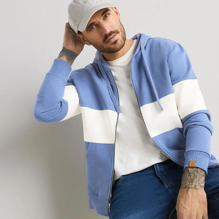 Avslappet stil: Bl&aring; hettegenser, hvit T-skjorte, jeans og gr&aring; caps.