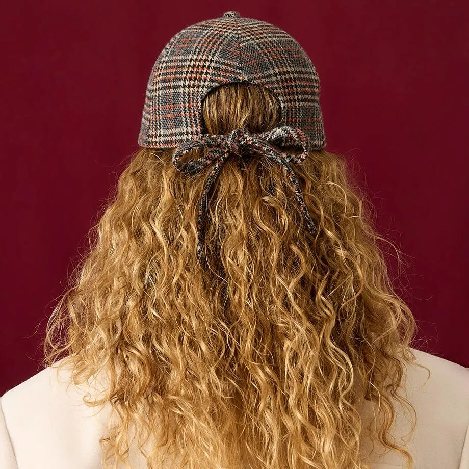 Rutete caps, kremfarget k&aring;pe og brun, ribbestrikket genser gir en stilfull look.