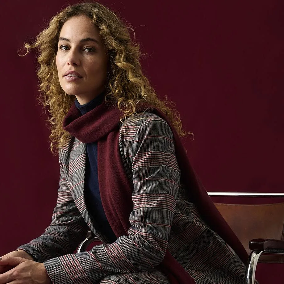 Rutete blazer, m&oslash;rkebl&aring; pologenser og et elegant, burgunderr&oslash;dt skjerf.