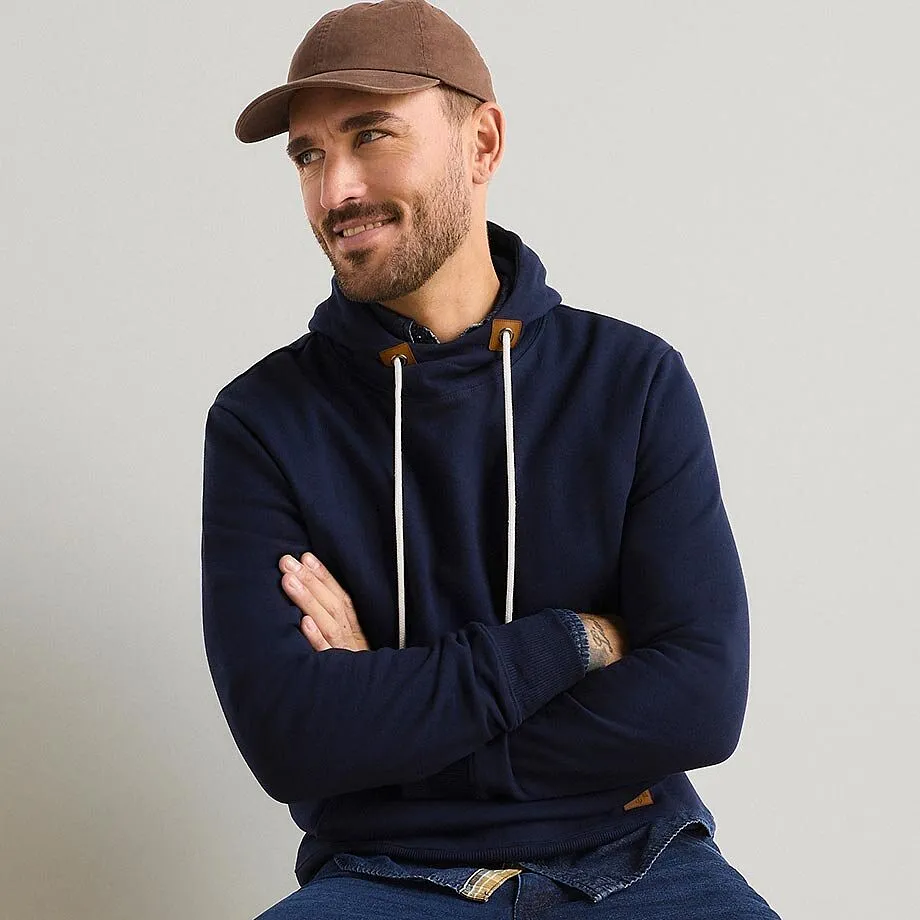 Avslappet antrekk med m&oslash;rkebl&aring; hoodie, brun caps og jeans.