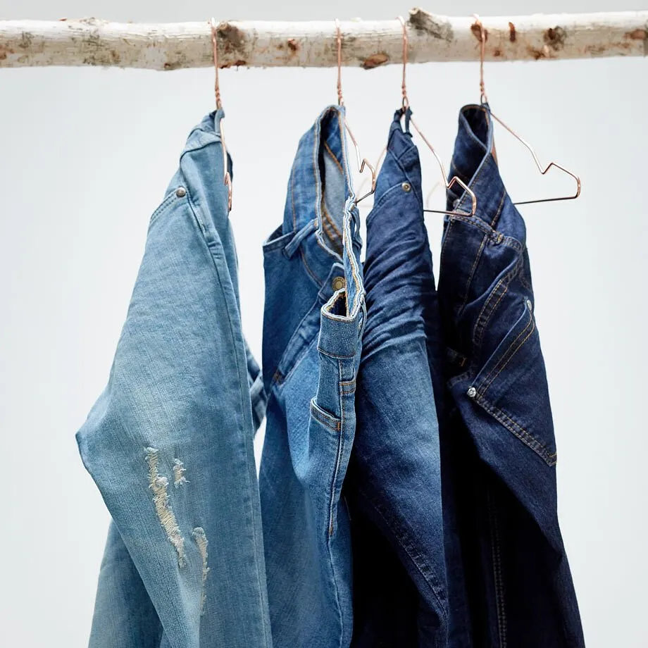 Jeans i ulike bl&aring;toner p&aring; kleshengere p&aring; en gren.