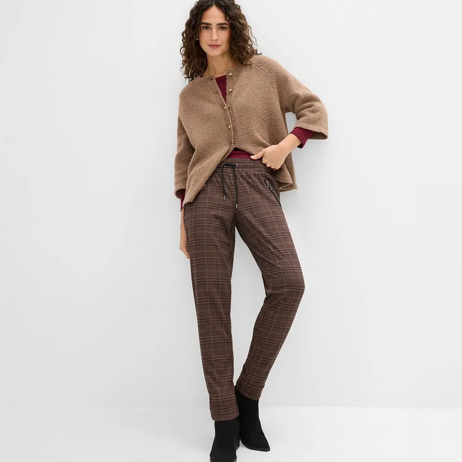 Brun cardigan, r&oslash;d topp, rutete bukse og sorte ankelst&oslash;vletter.
