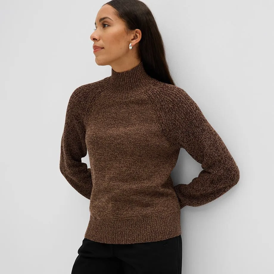 Brun melert, strikket genser med st&aring;krage og sort bukse for en elegant look.