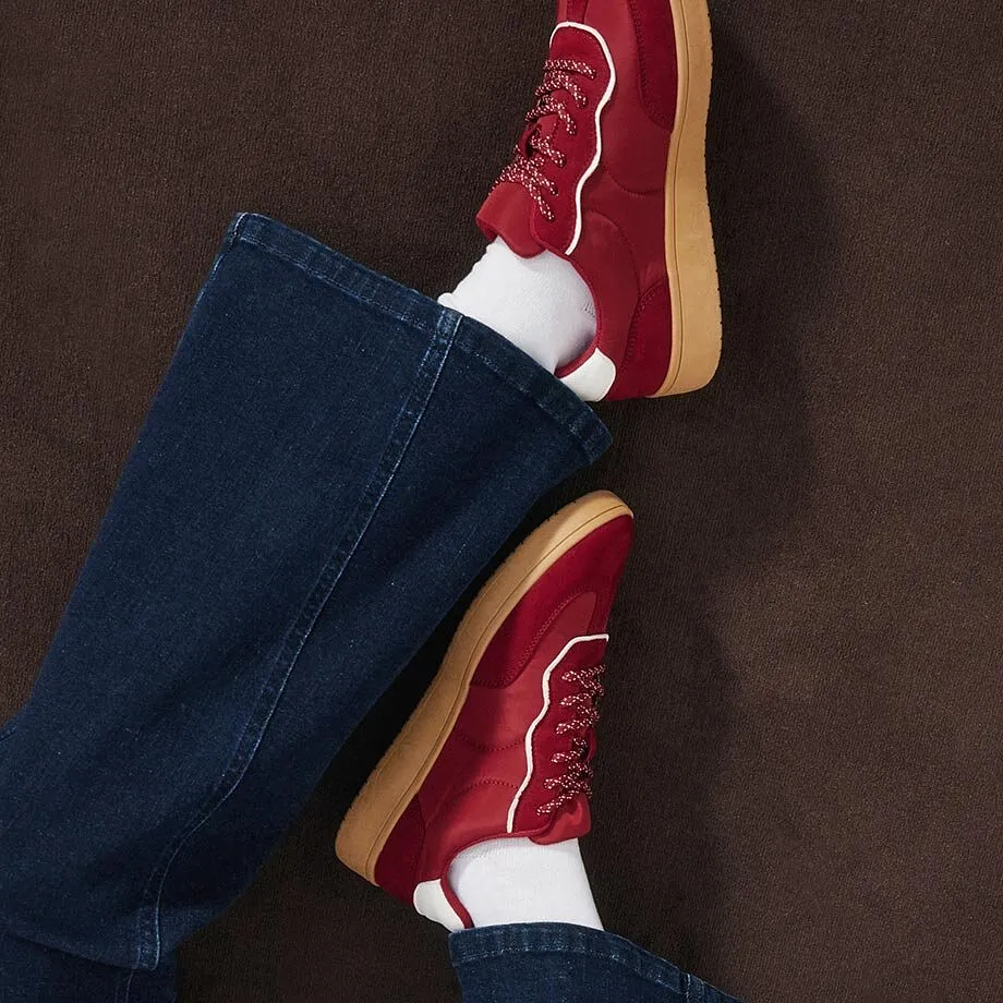 R&oslash;de sneakers, hvite sokker og m&oslash;rkebl&aring; jeans.