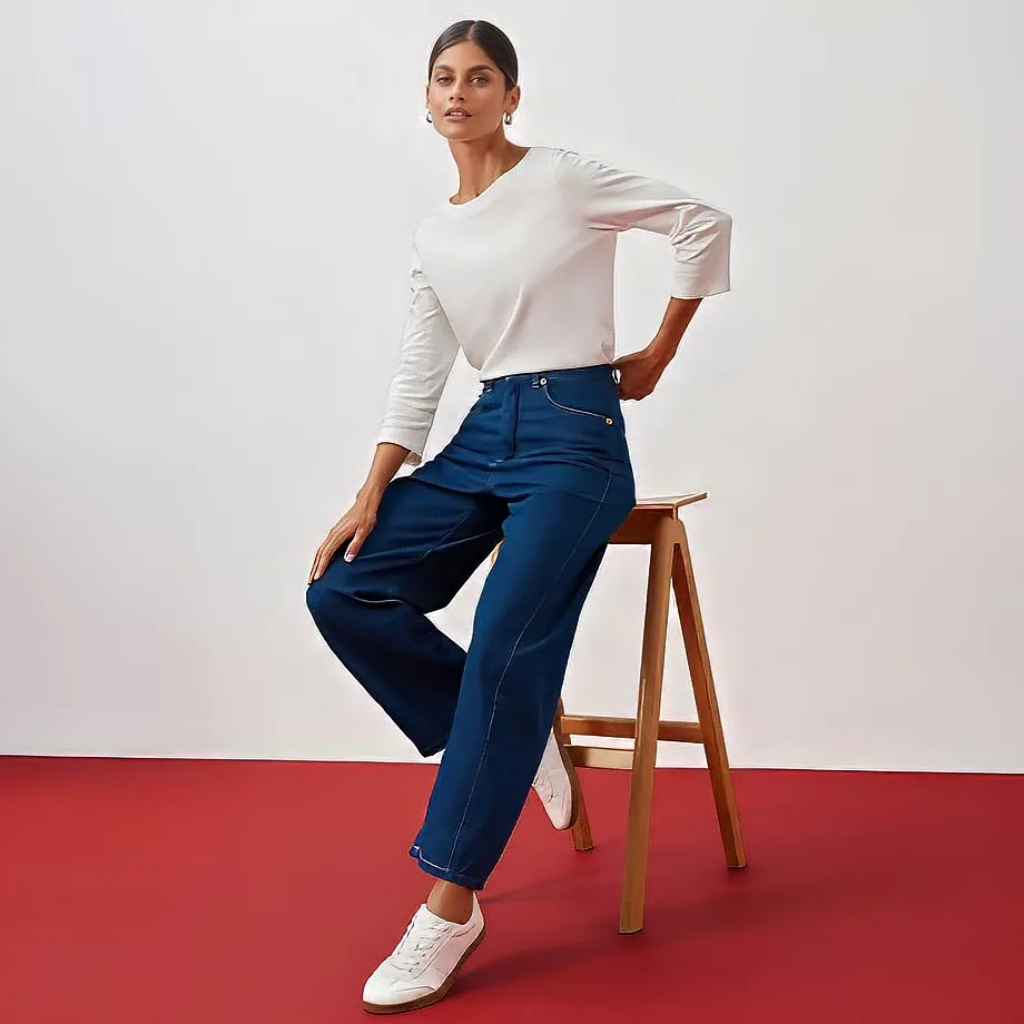 Hvit topp, bl&aring; jeans og hvite sneakers.
