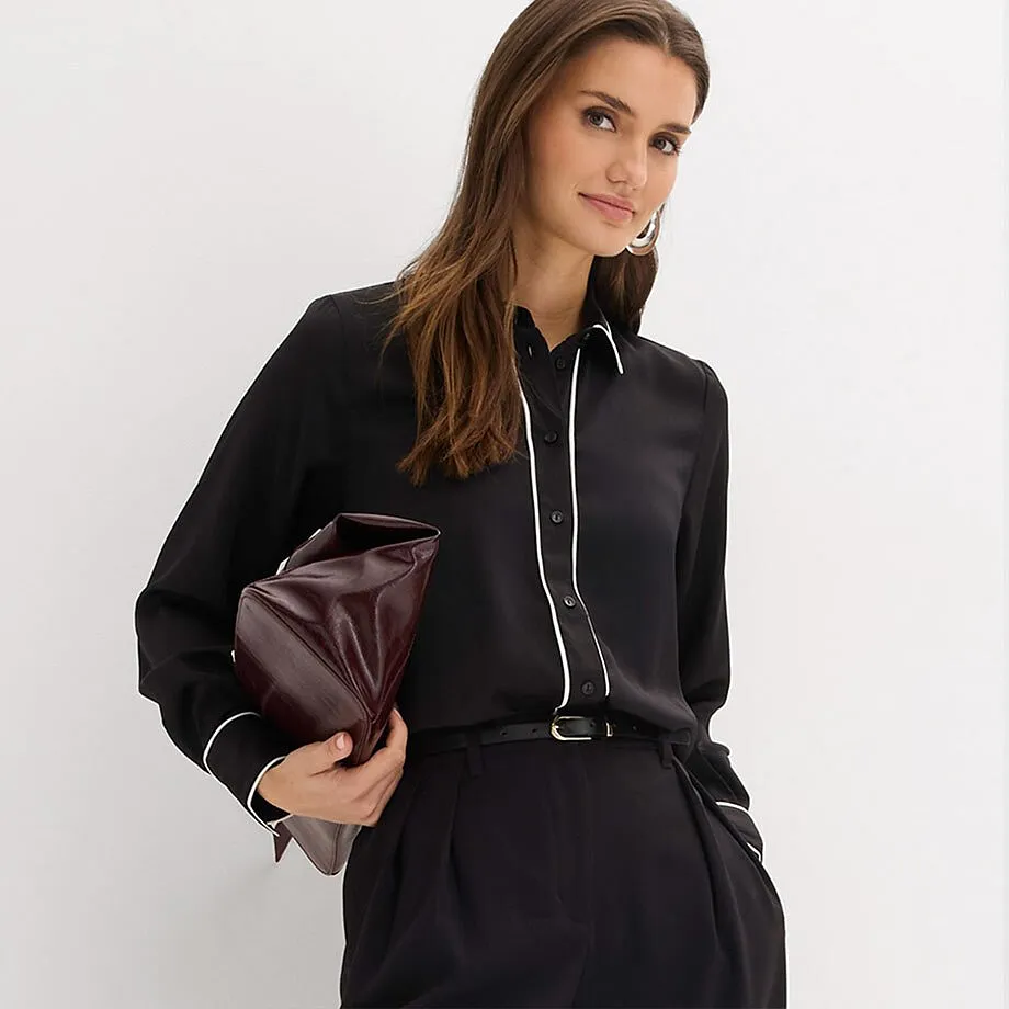 Sort skjorte med hvit krage kombinert med sort bukse.