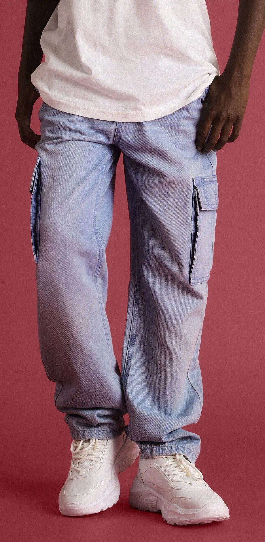 Avslappet antrekk best&aring;ende av bl&aring; jeans og hvite sneakers.