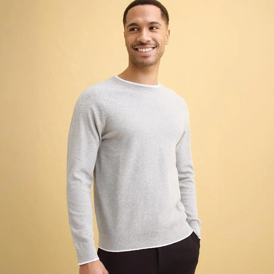 Lysegr&aring;, finstrikket genser med rund hals.