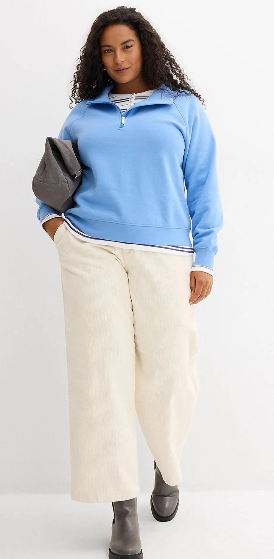 Lysebl&aring; genser og vid, kremfarget bukse.