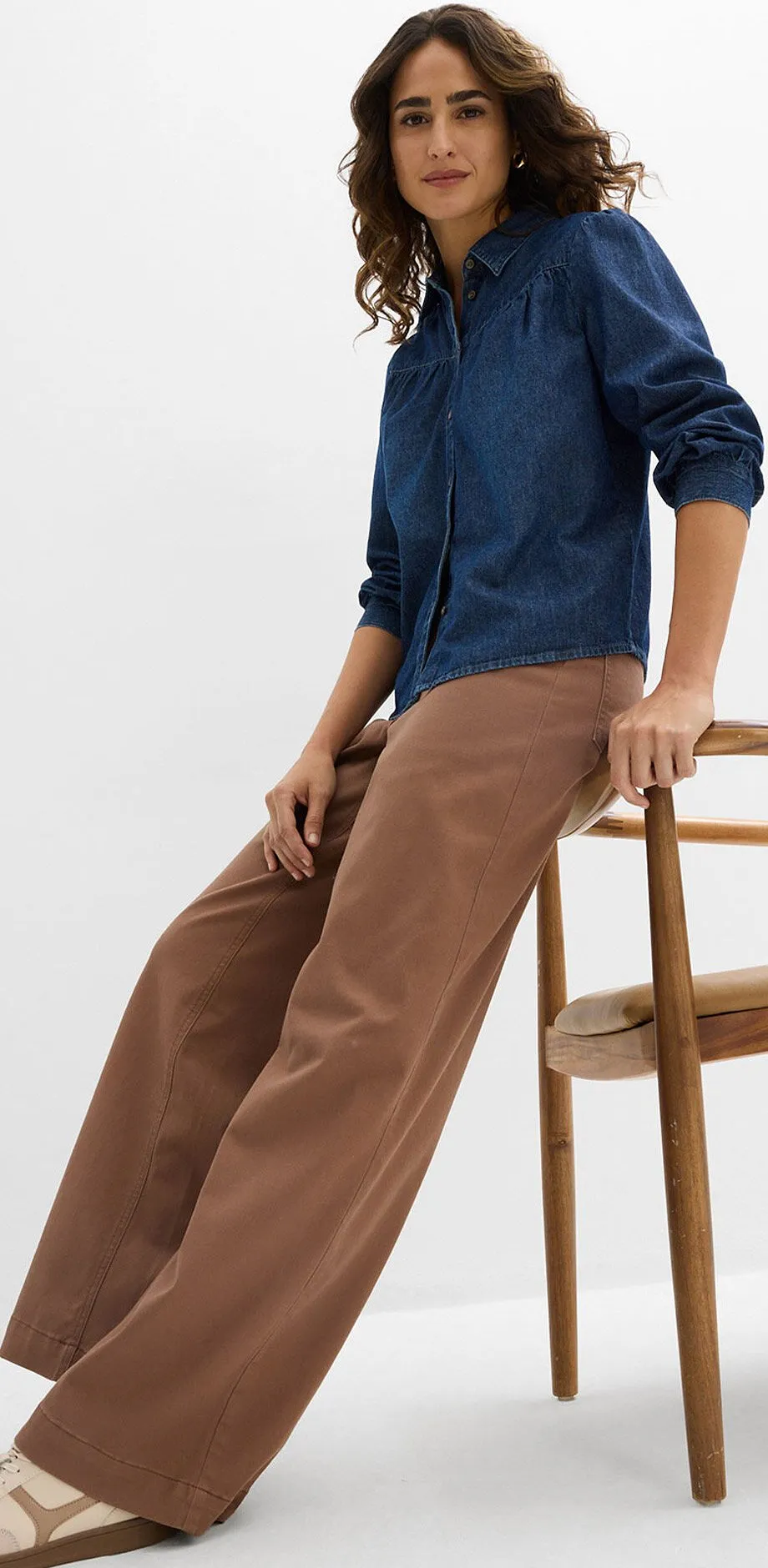 M&oslash;rkebl&aring; denimskjorte kombinert med brun bukse og lyse sneakers.