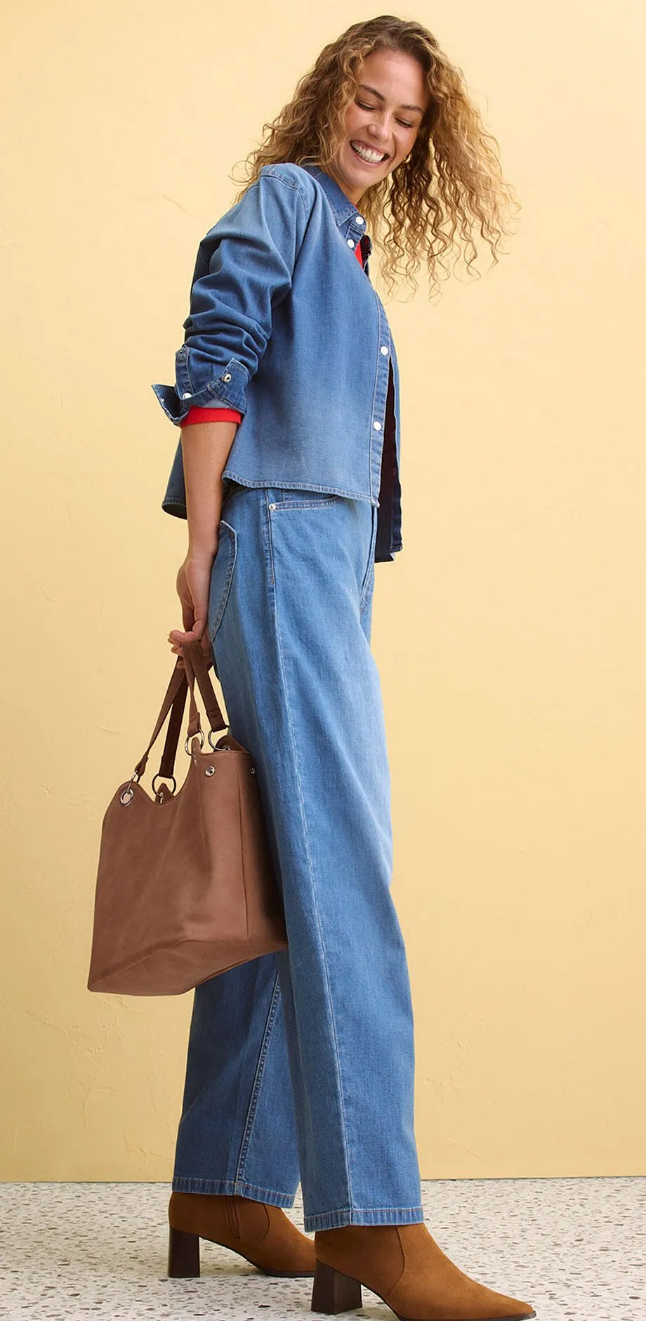 Antrekk i denim best&aring;ende av vid bukse og jakke kombinert med brunt tilbeh&oslash;r.