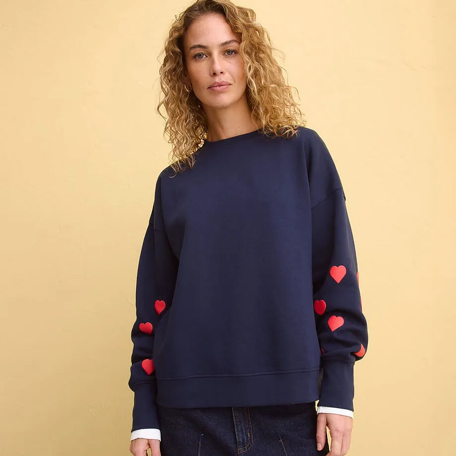 M&oslash;rkebl&aring; sweatshirt med applikerte, r&oslash;de hjerter p&aring; ermene.