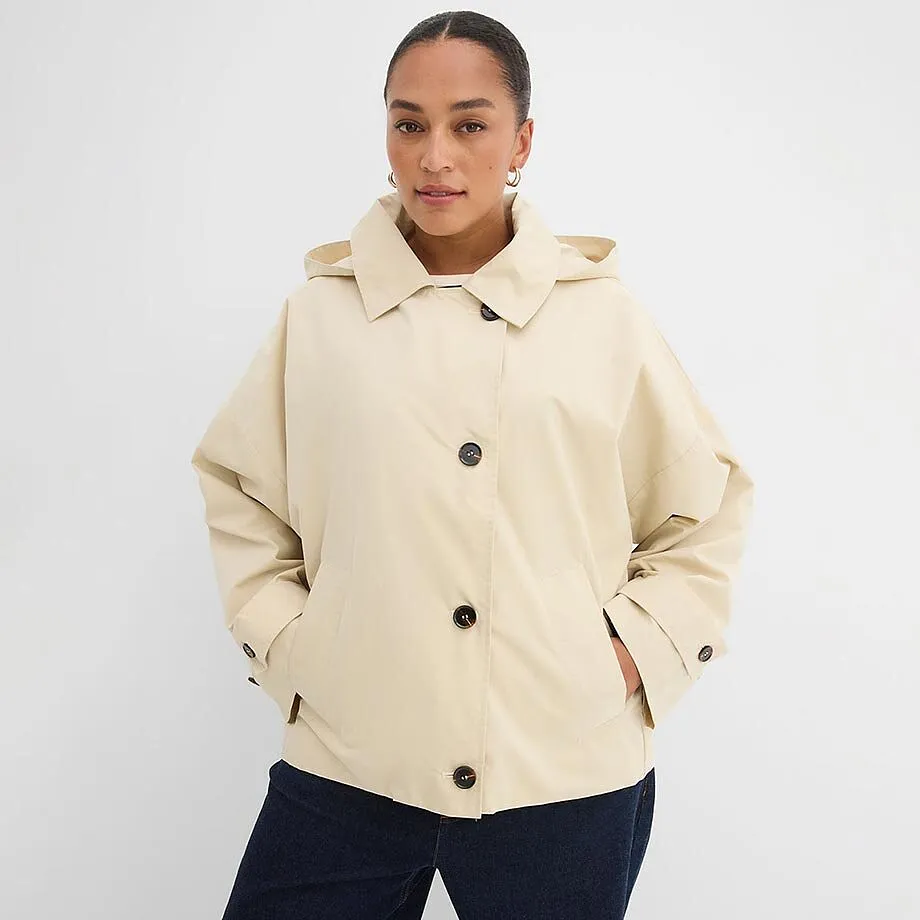 Kremfarget jakke med knapper og krage.