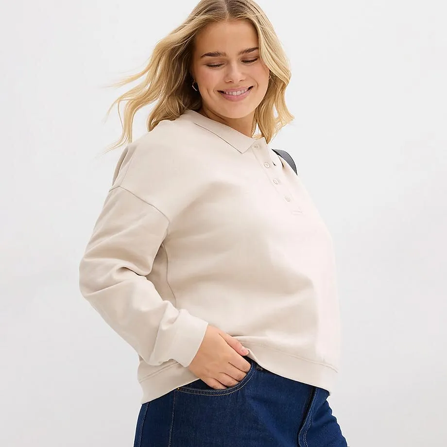 Beige sweatshirt kombinert med klassiske jeans.