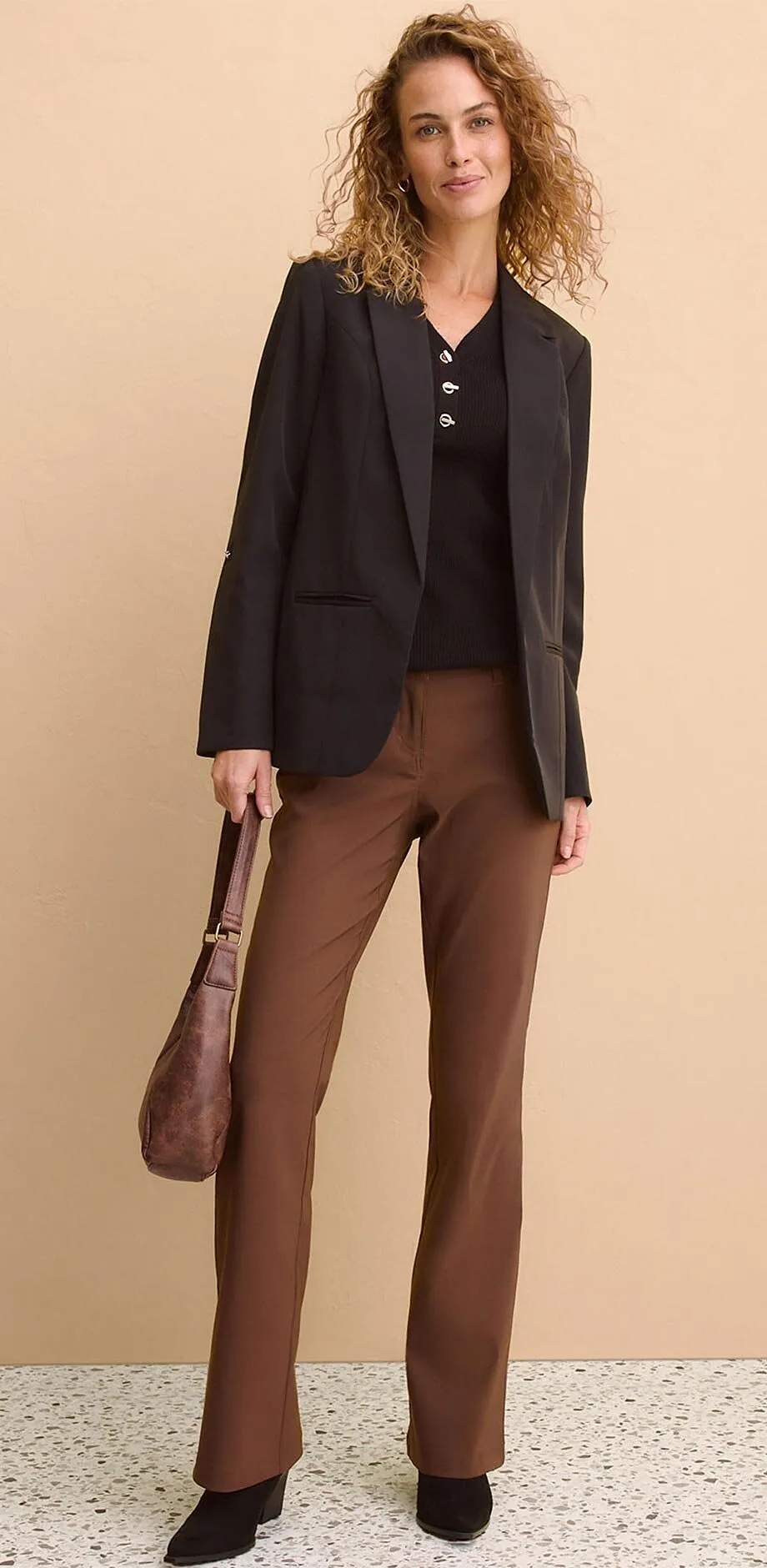 Sort blazer over m&oslash;rk topp kombinert med brun bukse.